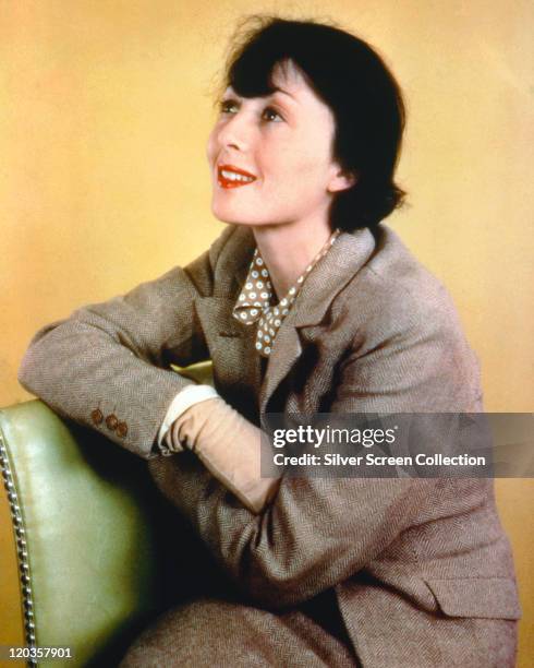 Luise Rainer, German actress, wearing a grey herringbone tweed jacket in a studio portrait, against a yellow background, circa 1945.