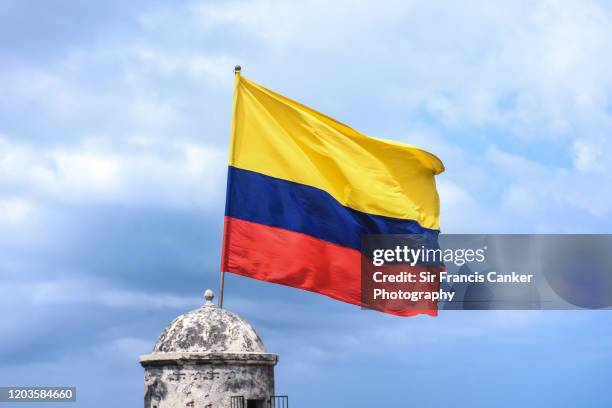 national flag of colombia waiving against dramatic sky in cartagena de indias, colombia - colonial flag stock pictures, royalty-free photos & images