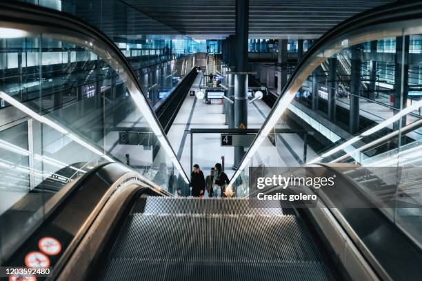 trois jeunes dans la station de métro berlin moderne - escalator photos et images de collection