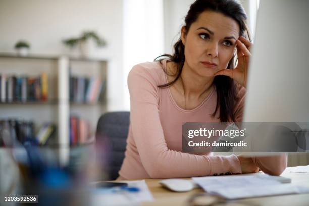 worried businesswoman looking at computer screen - killing time stock pictures, royalty-free photos & images