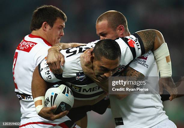 Matt Utai of the Tigers is tackled by Brett Morris and Matt Cooper of the Dragons during the round 22 NRL match between the Wests Tigers and the St...