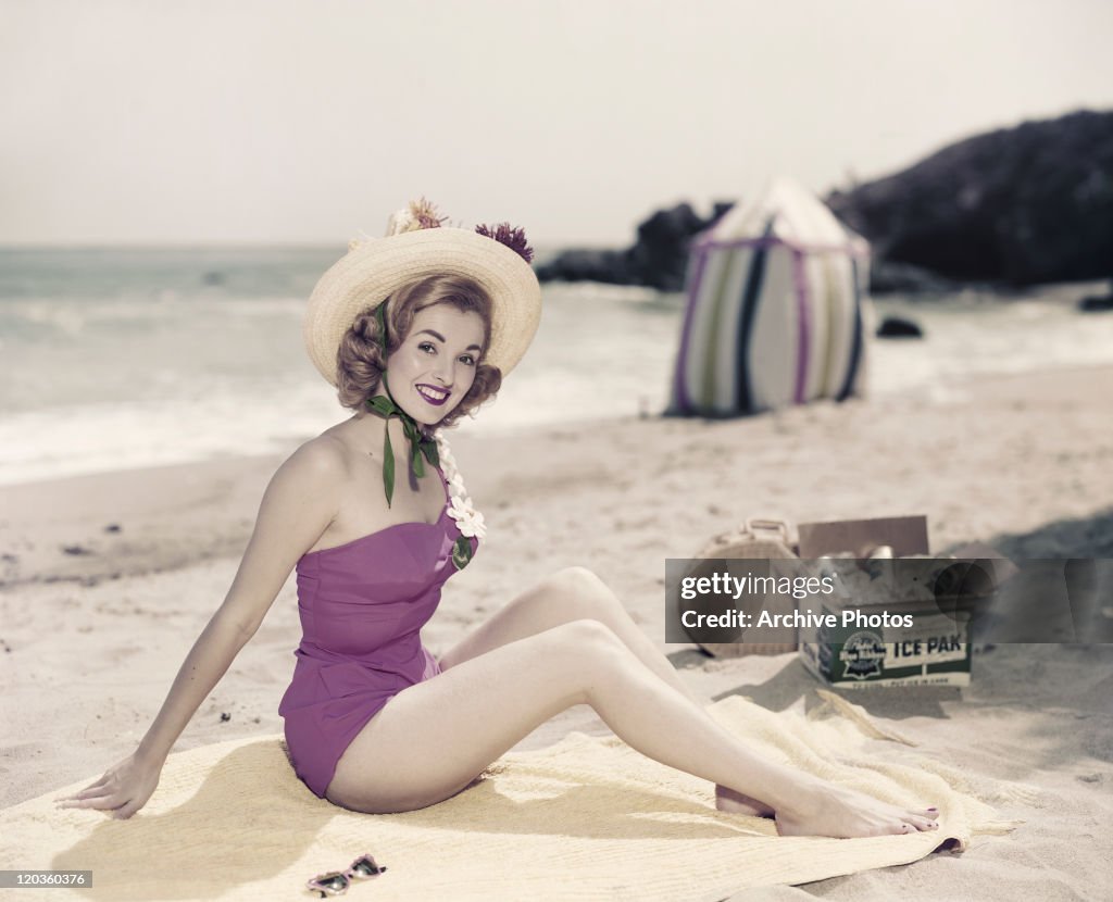 Young woman in swimwear at beach, portrait, smiling