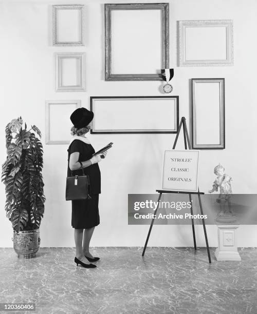 Woman looking empty picture frames