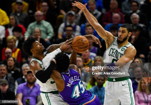 Marcus Smart and Jayson Tatum of the Boston Celtics guard Donovan Mitchell of the Utah Jazz during a game at Vivint Smart Home Arena on February 26,...