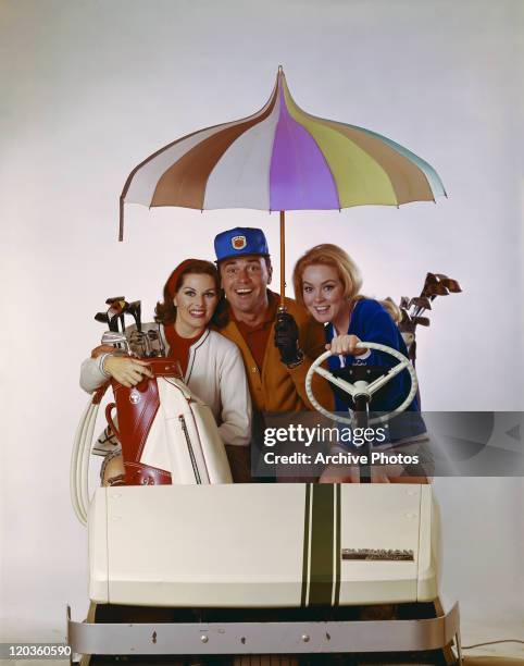 Man and women sitting in golf cart, smiling, portrait