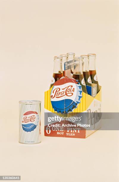 Cold drink bottles in six pack with drinks can on coloured background
