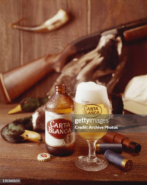 Glass of beer with bottle on wooden table