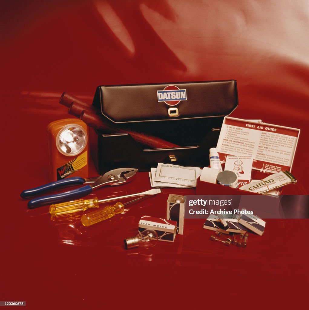 Toolbox with first aid kit on red background