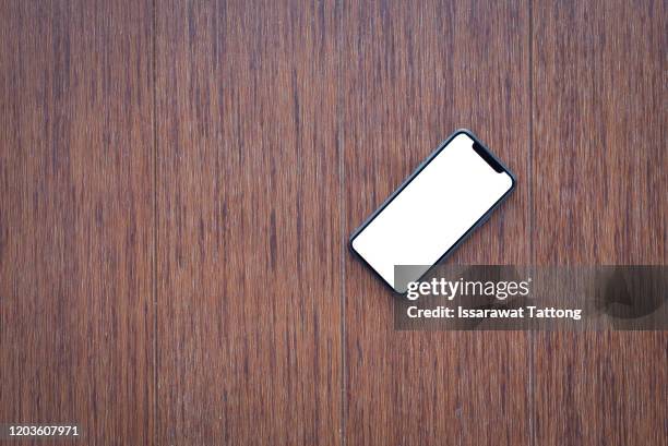 mobile phone with empty screen on wooden desktop. top view - desk tablet phone monitor stock pictures, royalty-free photos & images