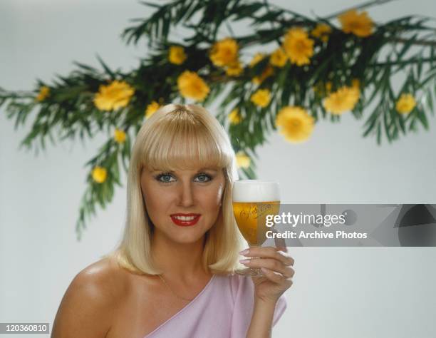 Blonde woman holding glass of beer, portrait