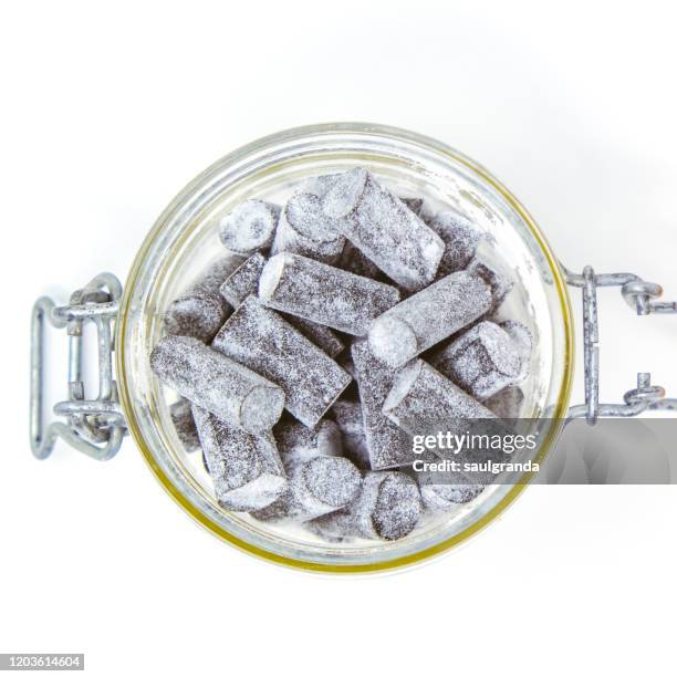 extra salty liquorice candies in a glass jar - liquorice stock-fotos und bilder