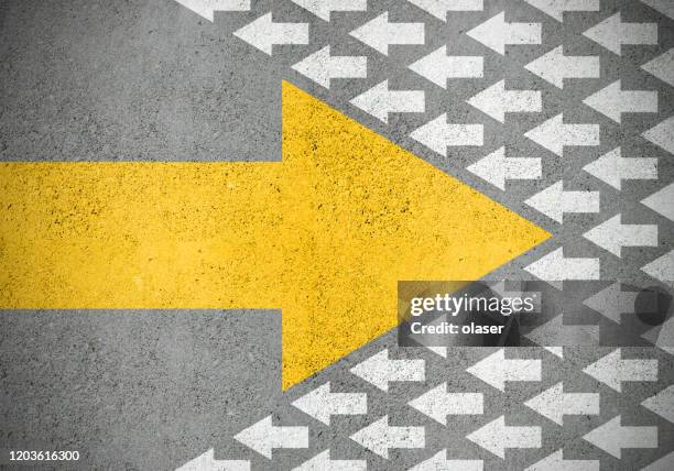 strong yellow (idea) arrow against smaller old white (methods) - managing director imagens e fotografias de stock