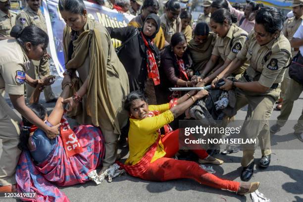 Police personnel detain members of Communist Party of India as they demand the resignation of Union Home Minister Amit Shah for the responsibility...