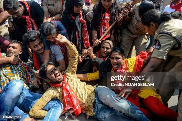 Police personnel detain members of Communist Party of India as they demand the resignation of Union Home Minister Amit Shah for the responsibility...