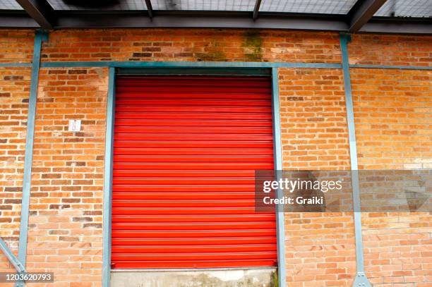 red industrial roll up door - rolling stockfoto's en -beelden