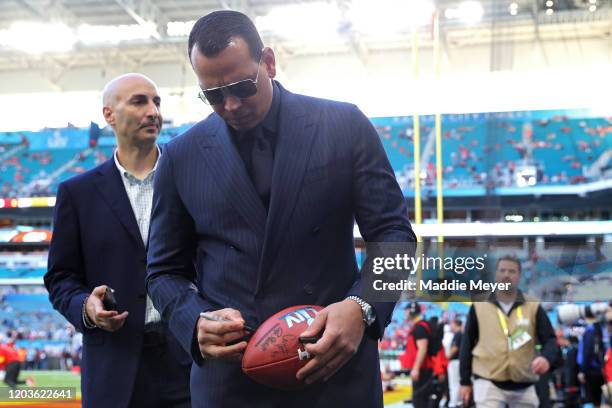 Former baseball player Alex Rodriguez autographs a ball before Super Bowl LIV at Hard Rock Stadium on February 02, 2020 in Miami, Florida.