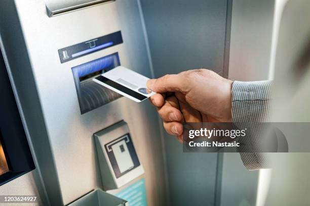 withdrawing money from atm machine by businessman - atm stock pictures, royalty-free photos & images