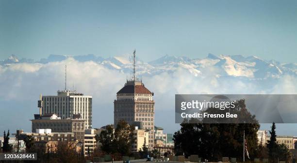 The downtown Fresno, Calif., skyline can be seen below snow caps the Sierra Nevada mountains and clouds along the foothills, Dec. 14, 2009.