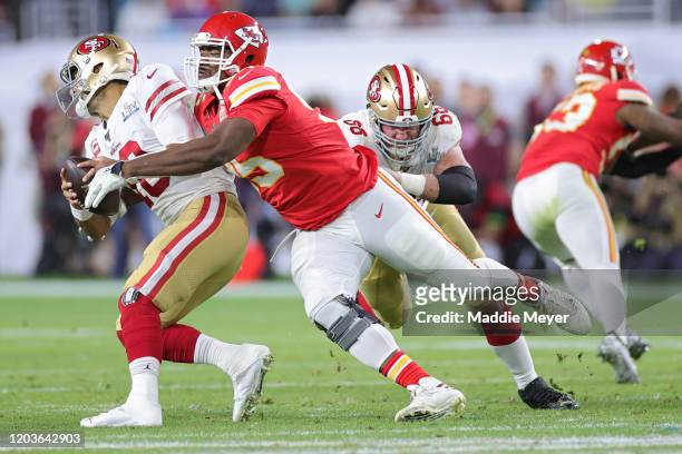 Jimmy Garoppolo of the San Francisco 49ers breaks a tackle from Chris Jones of the Kansas City Chiefs during the second quarter in Super Bowl LIV at...