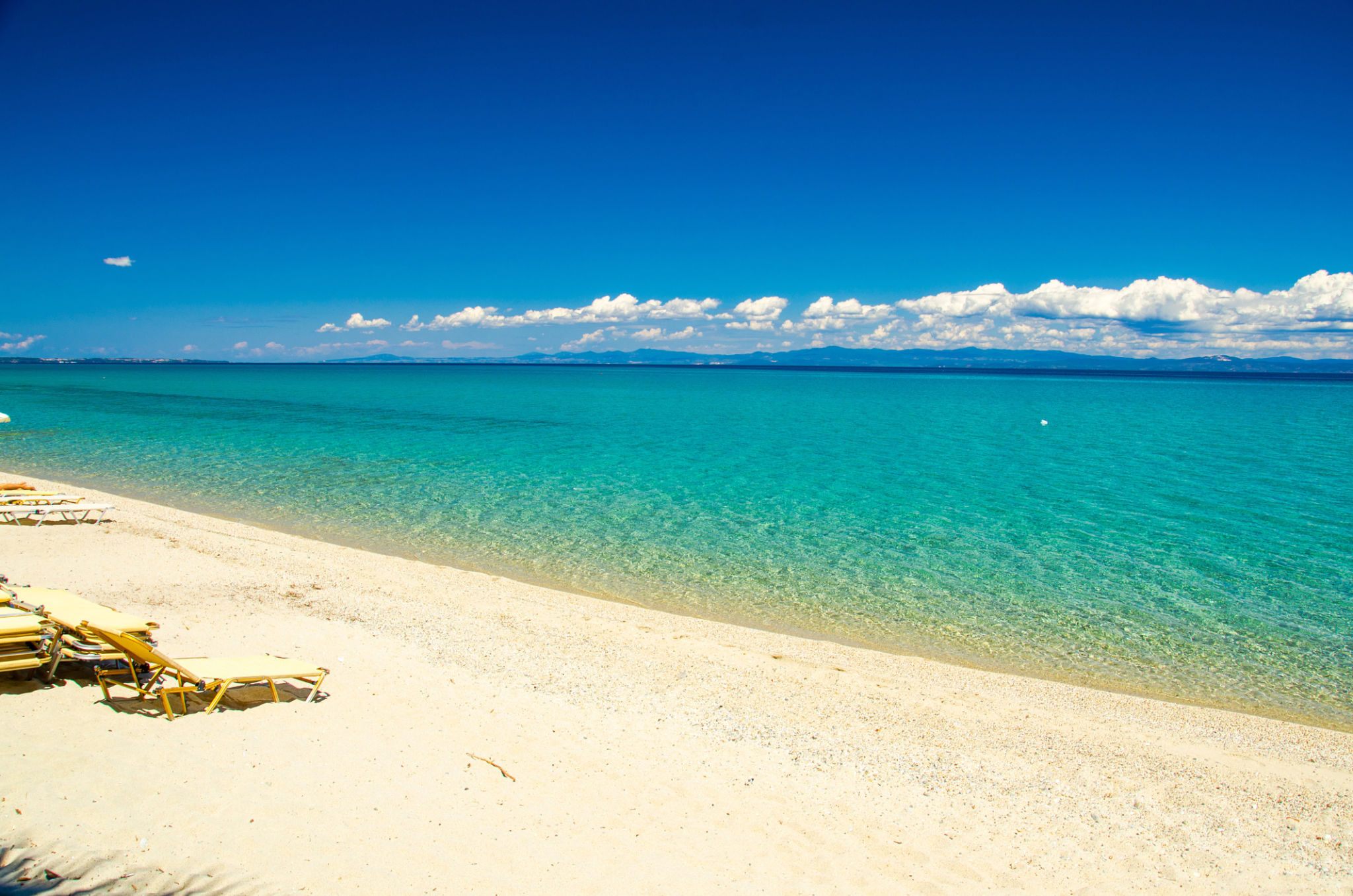 Sandy beach with blue paradise water, Halkidiki, Kassandra, Greece Sandy beach with blue paradise water, Halkidiki, Kassandra, Greece