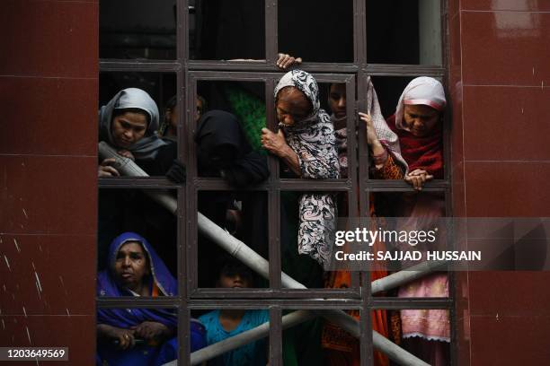 Residents look down from a building during the funeral of Mohammad Mudasir who died in the recent sectarian riots in India's captial over Prime...