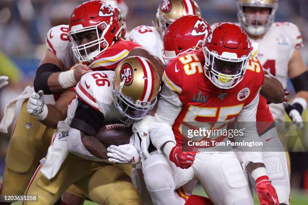 Tevin Coleman of the San Francisco 49ers is tackled by Frank Clark of the Kansas City Chiefs in Super Bowl LIV at Hard Rock Stadium on February 02,...