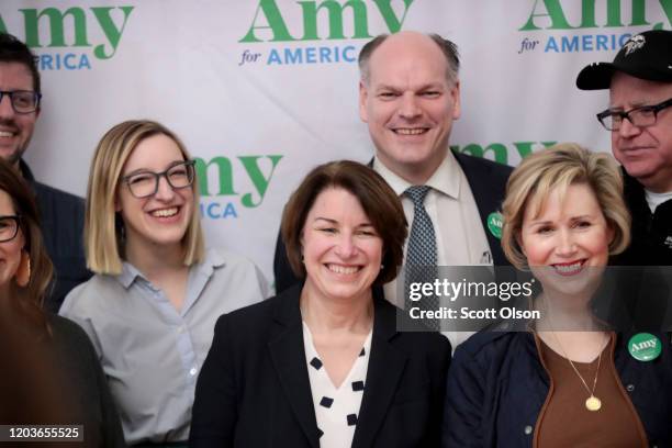 Democratic Presidential Candidate Sen. Amy Klobuchar , flanked by her husband John Bessler and daughter Abigail, poses for a picture with guests...