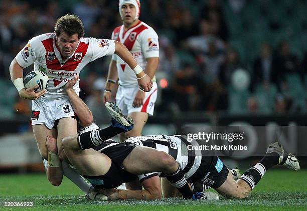 Adam Cuthbertson of the Dragons is tackled during the round 22 NRL match between the Wests Tigers and the St George Illawarra Dragons at Sydney...