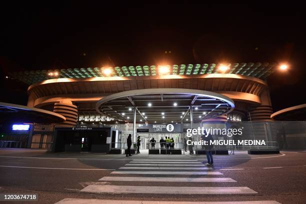 Stewards stand guard in front of the San Siro stadium closed to the public as a safety measure against the COVID-19, the novel coronavirus, ahead of...