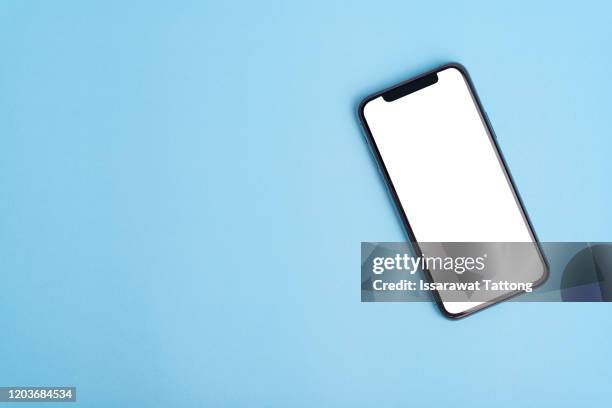 flat lay on blue workspace with cell phone gadget, .blue textured office desk. deadline concept. copy space, background, top view. - office desk top view stockfoto's en -beelden