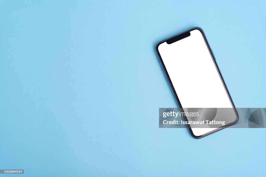 Flat lay on blue workspace with cell phone gadget, .blue textured office desk. Deadline concept. Copy space, background, top view.