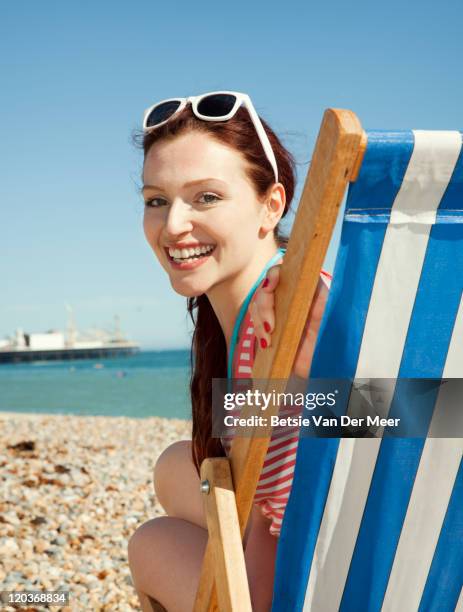 portrait of woman in deckchair on beach. - deck chair stock pictures, royalty-free photos & images