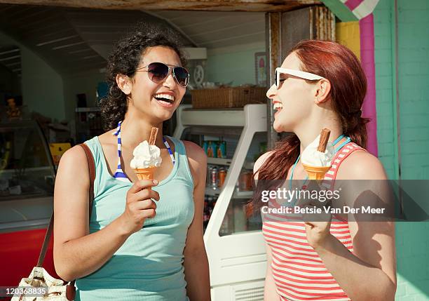 female friends with icecreams in front of shop. - ice cream parlour stock pictures, royalty-free photos & images