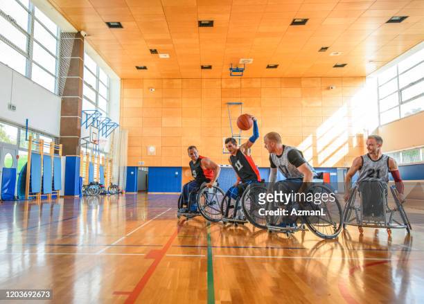 male wheelchair basketball players battling mid court - wheelchair basketball team stock pictures, royalty-free photos & images