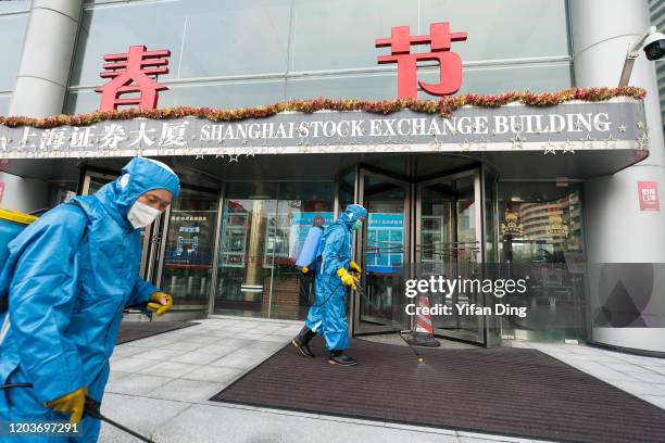 Medical workers spray antiseptic outside of the main gate of Shanghai Stock Exchange Building on February 03, 2020 in Shanghai, China.