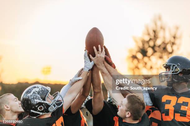 american football players huddling during time out - american football team huddle stock pictures, royalty-free photos & images