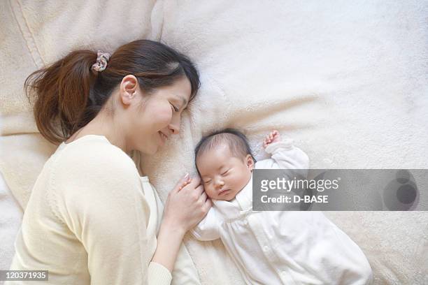 mother and baby in bed - 日本人　赤ちゃん ストックフォトと画像