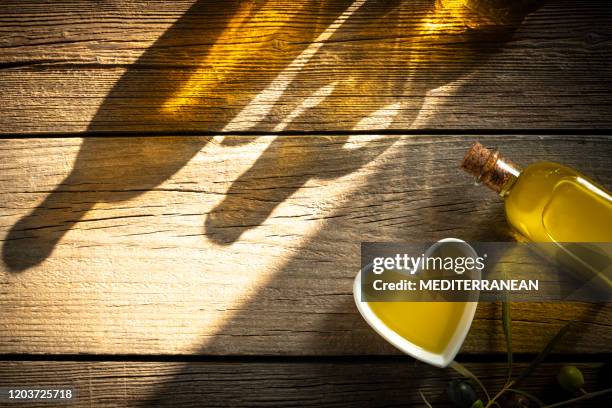 olive oil bottles and heart shape bowl as heart healthy food - wellness olive tree stock pictures, royalty-free photos & images