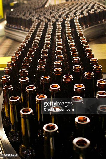 Glass beer bottles move down a conveyor belt at the Owens-Illinois Inc. Glass manufacturing plant in Waco, Texas, U.S., on Thursday, Aug. 4, 2011....