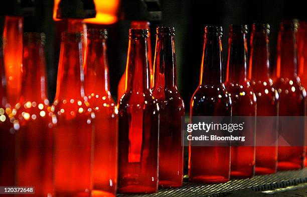 Glass beer bottles move down a conveyor belt at the Owens-Illinois Inc. Glass manufacturing plant in Waco, Texas, U.S., on Thursday, Aug. 4, 2011....