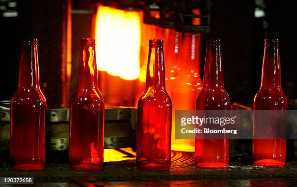 Shiner Beer bottles exit a forming machine at the Owens-Illinois Inc. Glass manufacturing plant in Waco, Texas, U.S., on Thursday, Aug. 4, 2011....