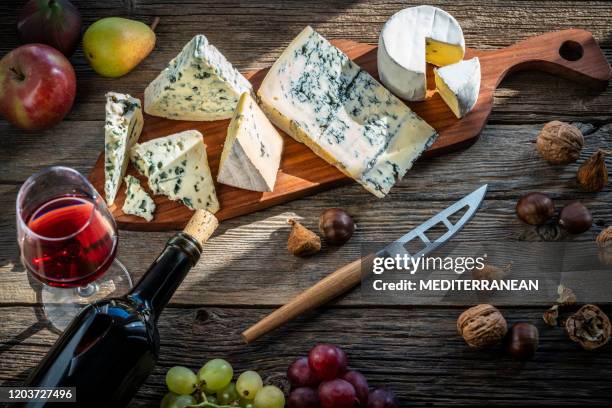 blue cheese and red wine in cutting board - roquefort cheese stock pictures, royalty-free photos & images
