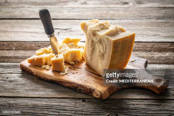 parmesan reggiano cheese on cutting board - french cheese stock pictures, royalty-free photos & images