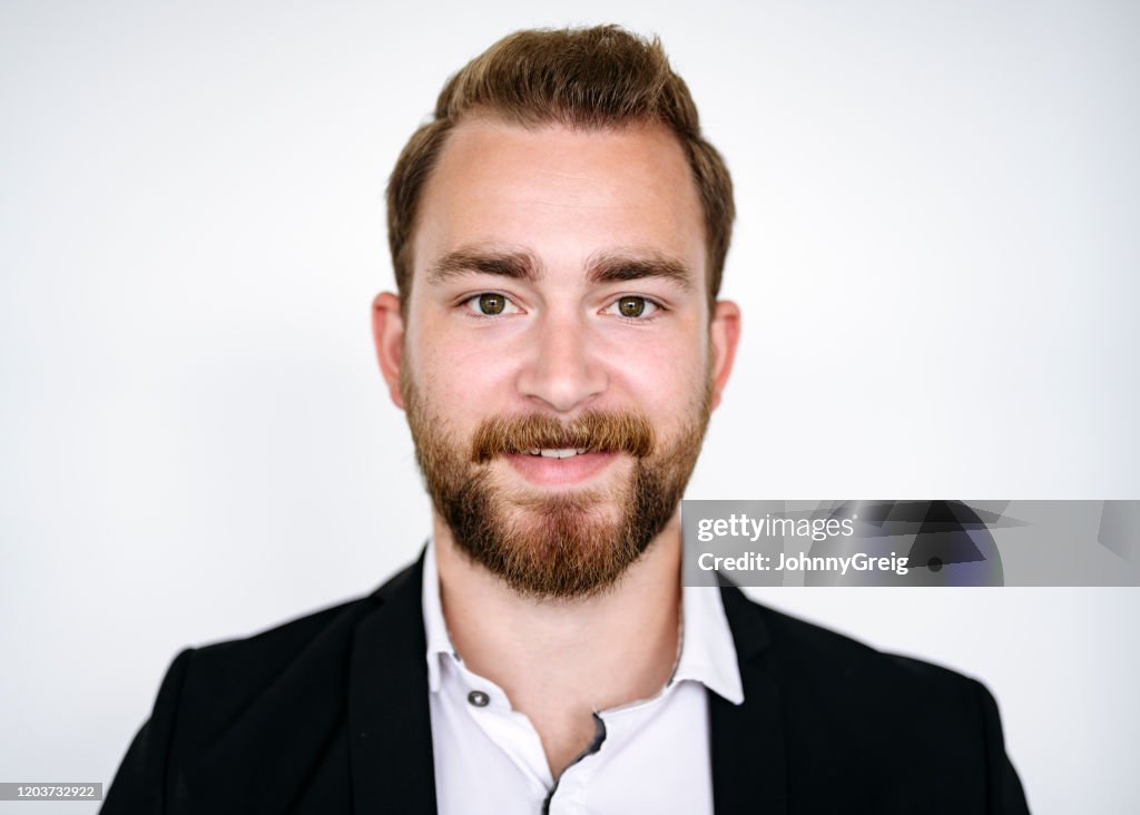 Retrato de un hombre de negocios caucásico sonriente a principios de los años 20