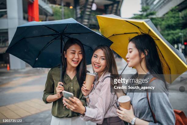 women using smart phone on the street - pavement cafe imagens e fotografias de stock
