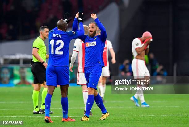 Getafe's Cameroonian defender Allan Nyom celebrates with Getafe's Spanish midfielder David Timor Copovi during the UEFA Europa League round of 32...