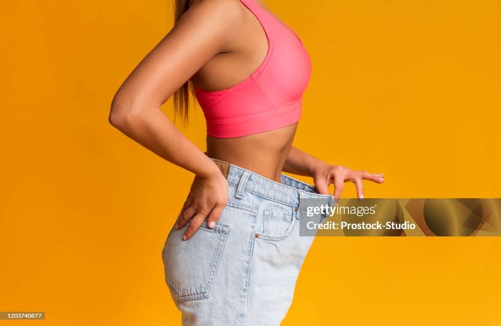 Fit Girl Posing in Oversize Jeans OverBackground