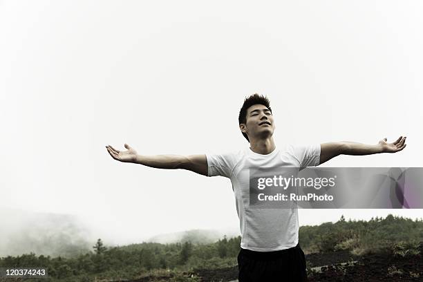 young man,outdoor exercise - man with arms raised stock pictures, royalty-free photos & images