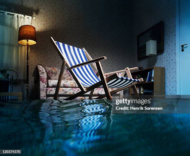 deckchair in flooded living room - flooded room stock-fotos und bilder