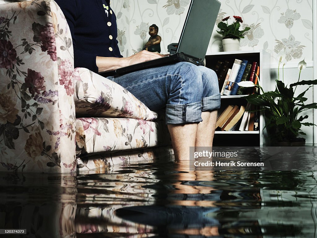 Man in sofa in flooded room